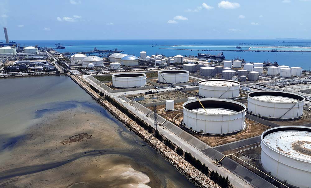 Large fuel storage tanks sitting at an ocean port.