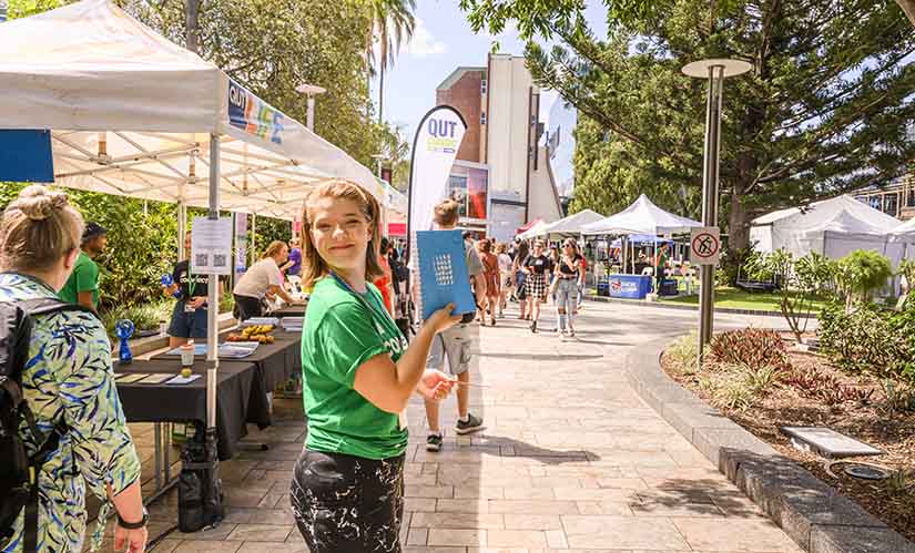 Young woman hands out diary at O Week