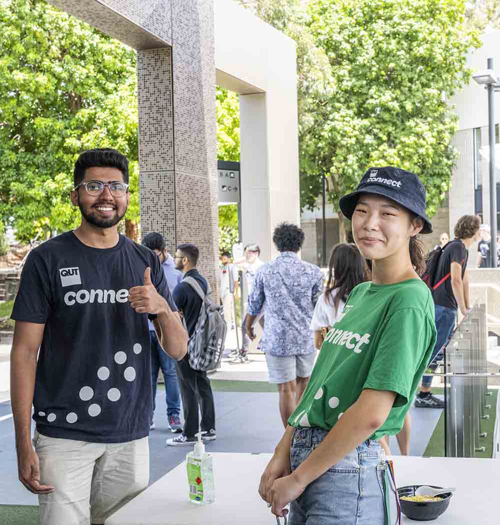 Two volunteer uni students greet new comers to QUT at Orientation Week.