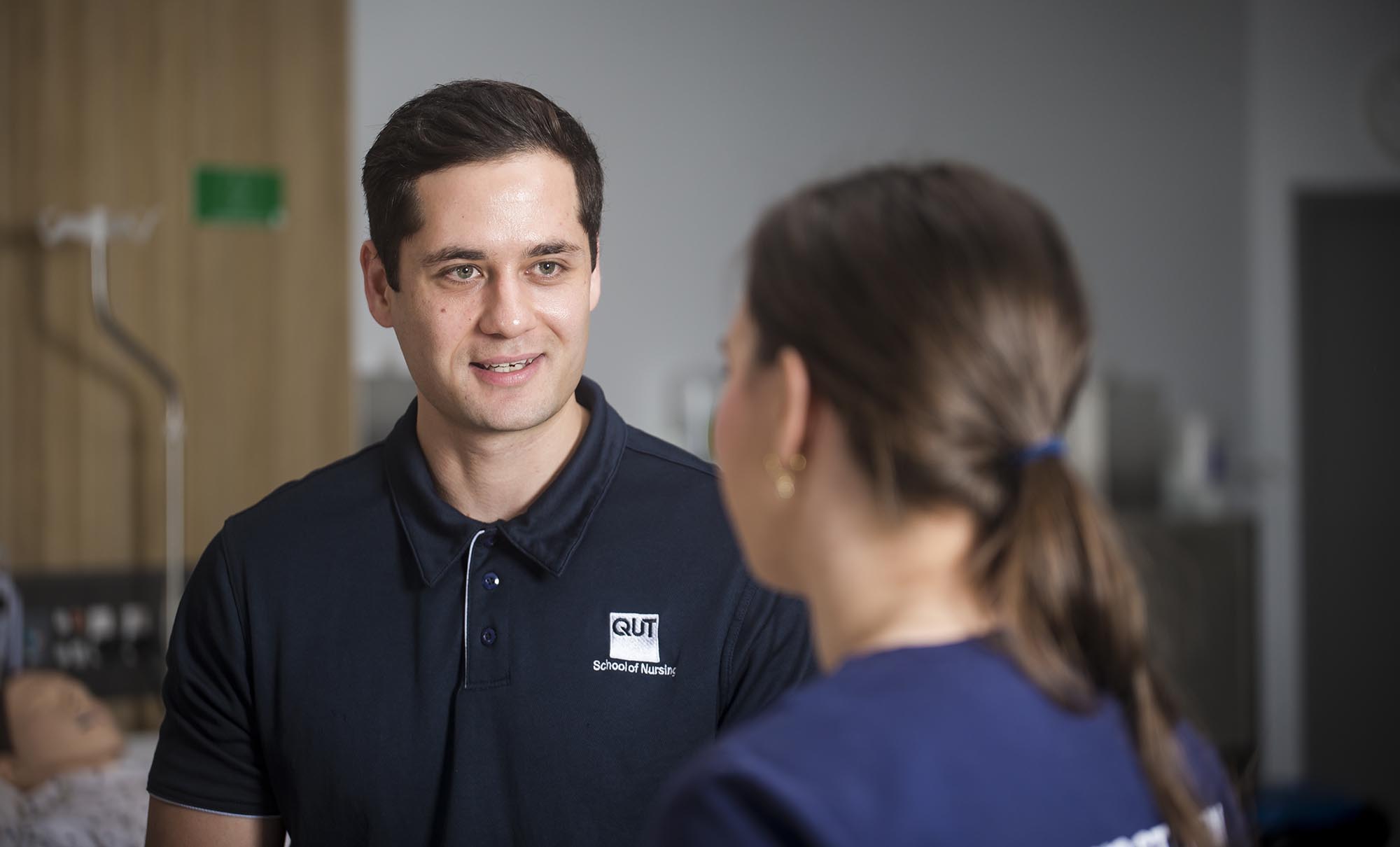 A male nursing student chatting to a female nursing student.