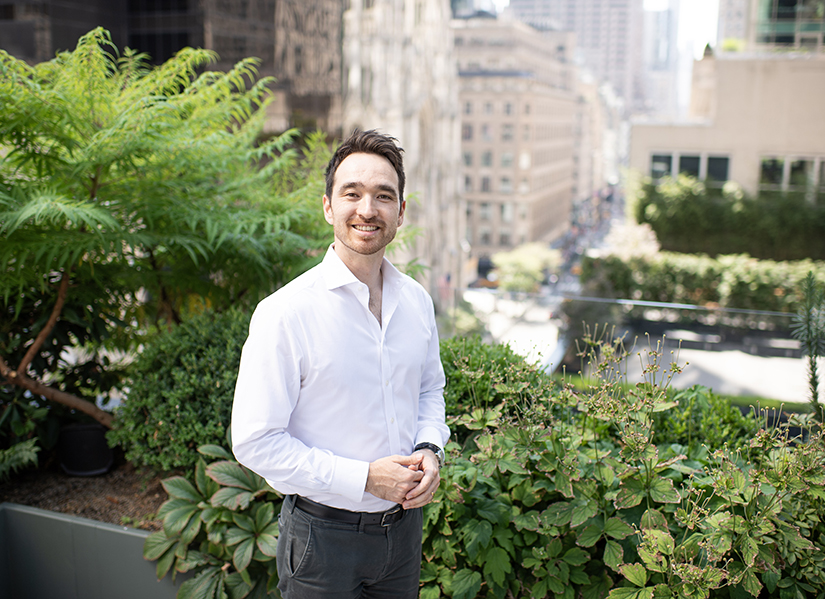Jesse Lock on balcony in New York City surrounded by greenery
