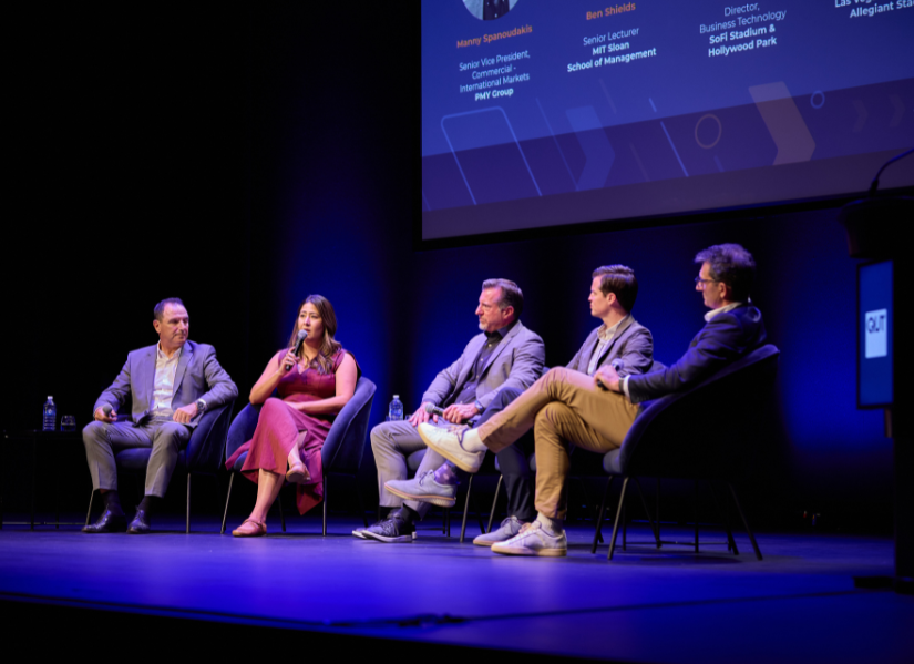 panel of speakers sit on a stage for the Future of Sport Conference