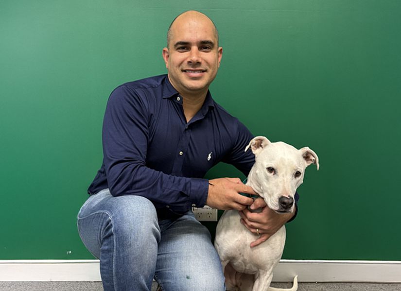 Gui hugging a white dog
