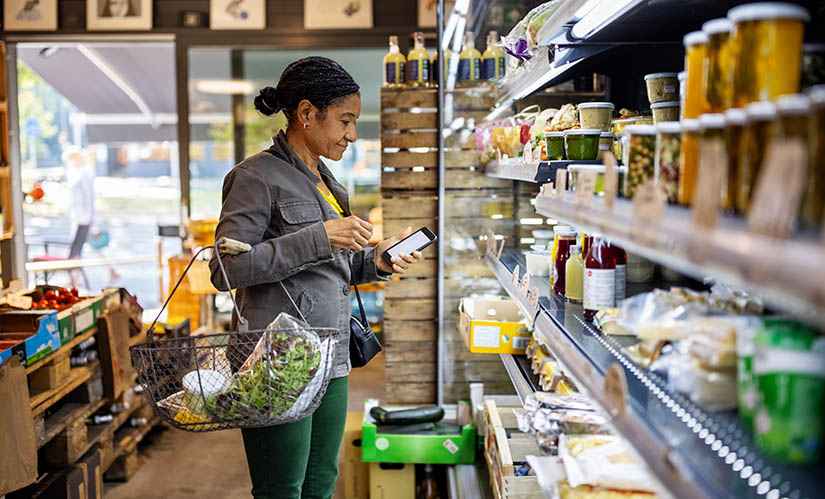 Woman buys grocery items from list.