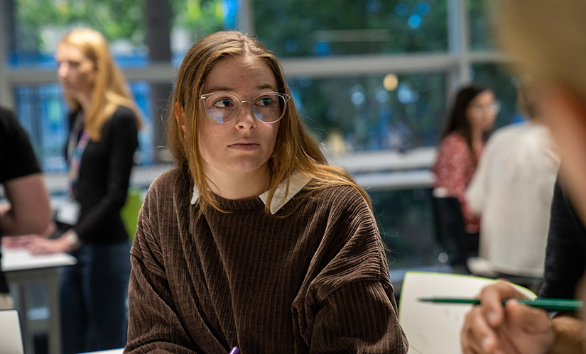 A female student sitting in a crowded classroom.