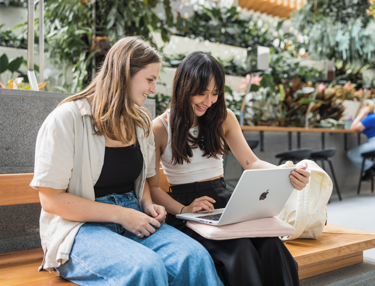 Two students looking at a laptop, studying