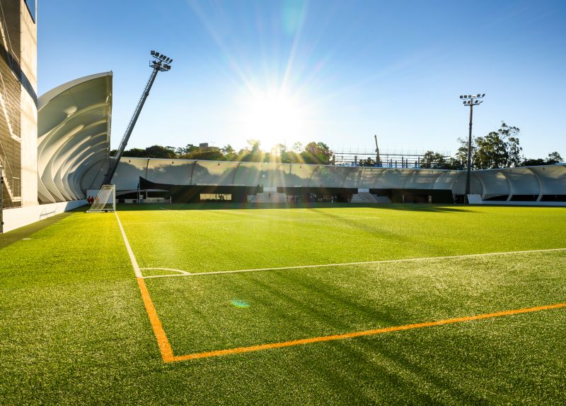 Sports field with sun in background at QUT