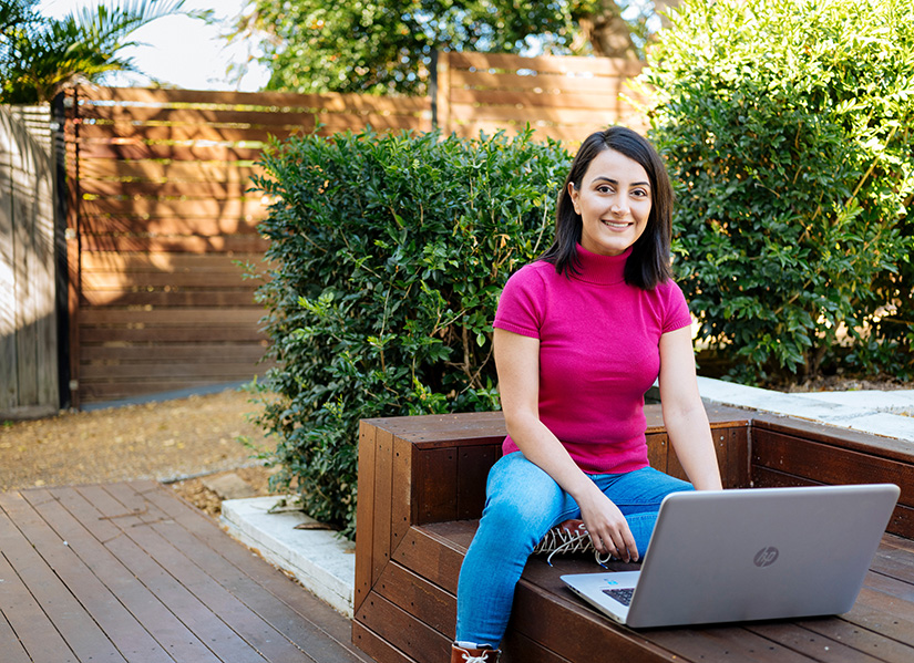 Female student on laptop outside