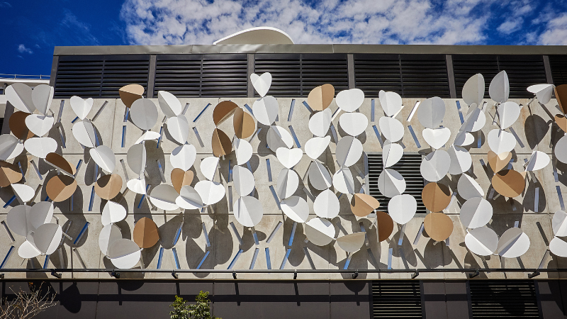 The outside of a building with butterfly like wings attached all along it.