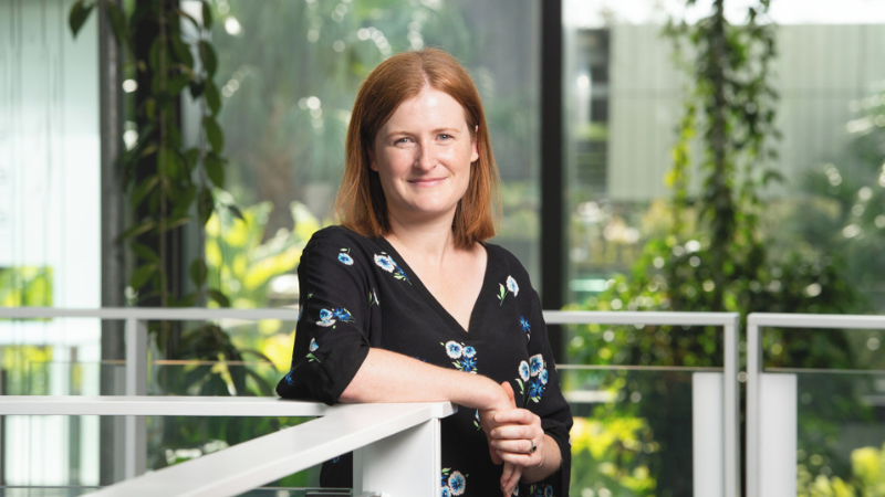 Researcher stands smiling for the camera.