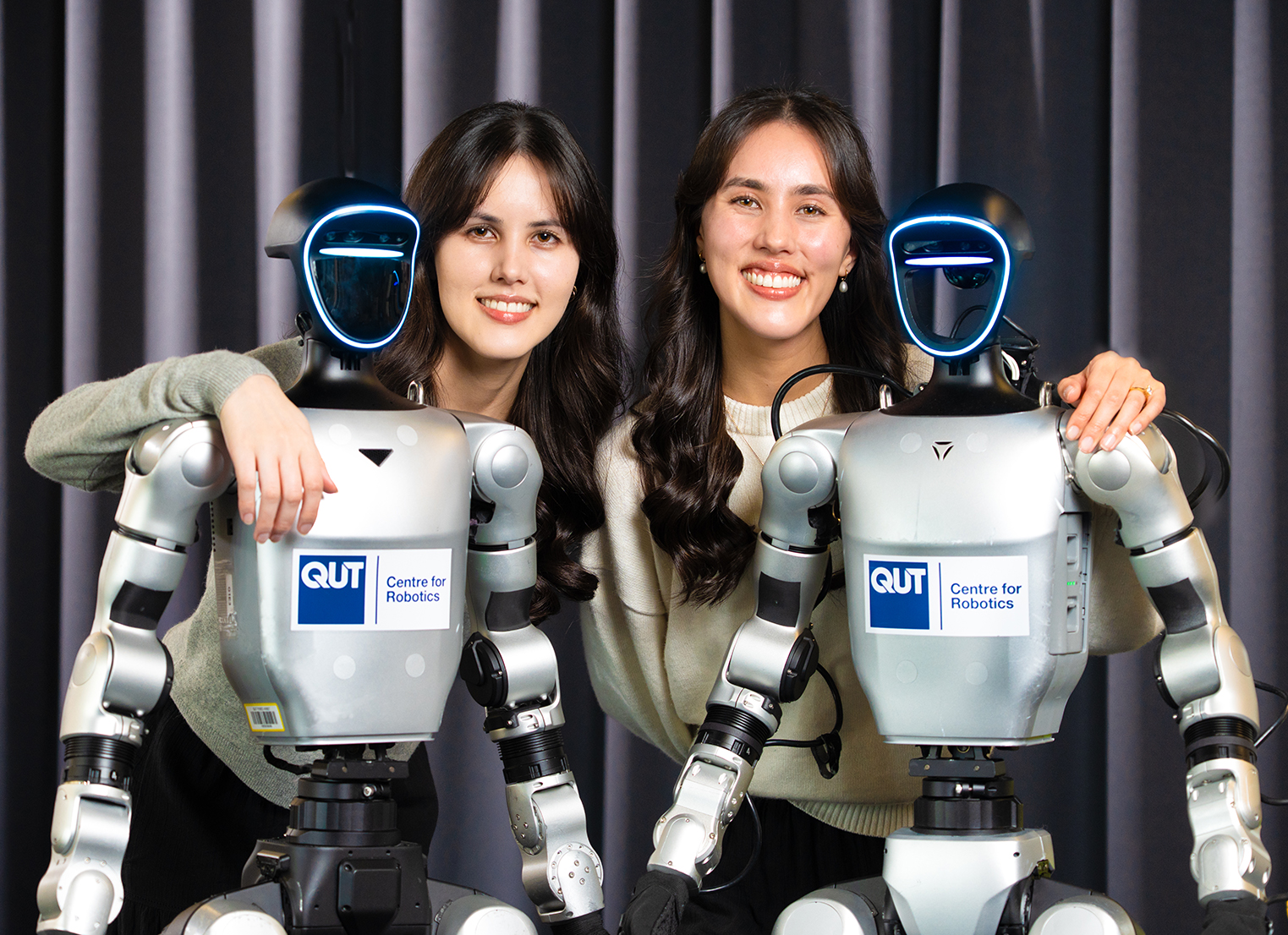 Brittany Gorry and Beverley Gorry with two humanoid robots from the QUT Centre for Robotics