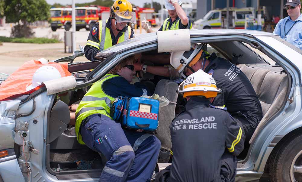 A QUT paramedic student and a Fire and rescue officer train together responding to a simulated car crash