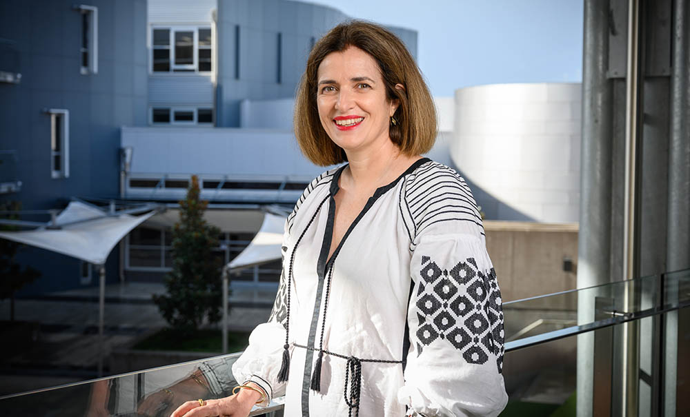 Associate Professor Helen Vidgen wears a white blouse and smiles at the camera.