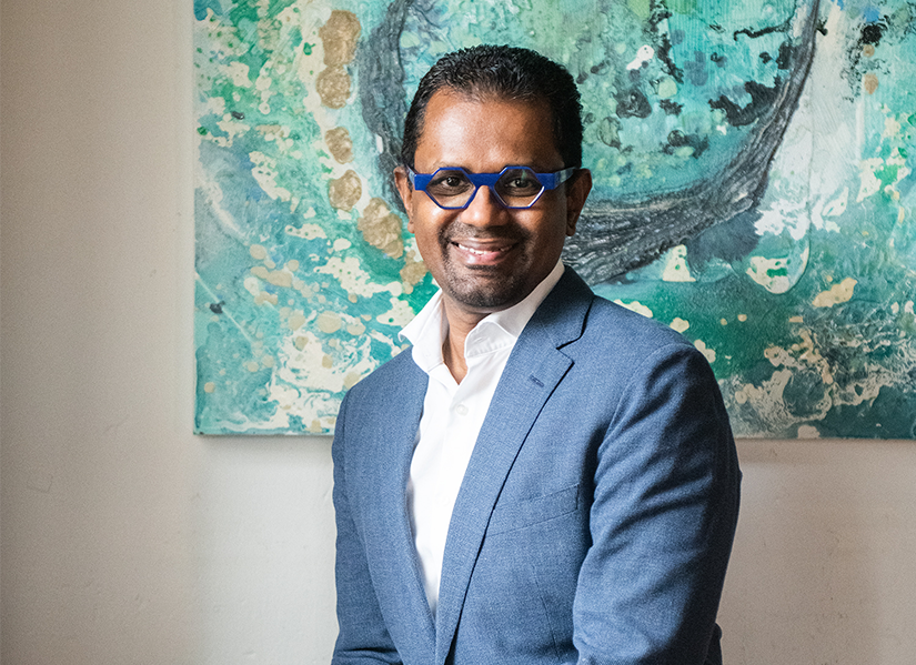 Headshot of Viyu Chakarapany. He is wearing a blue suit with a white button down shirt. He has darker skin, and is wearing blue framed glasses.