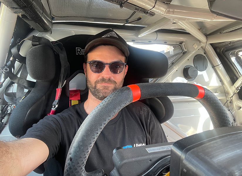 Jacob filming on set in a V8 supercar