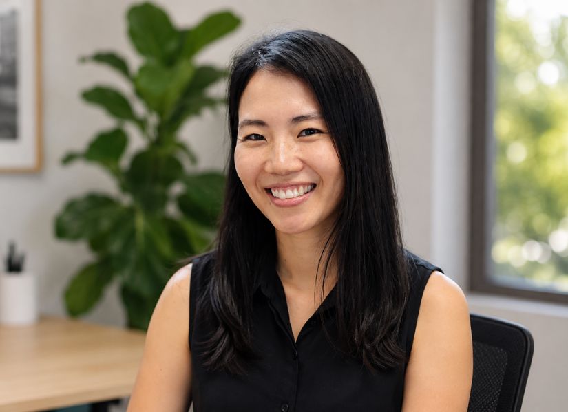 Helena Uhm smiles directly to camera. Wearing a black sleeveless top.