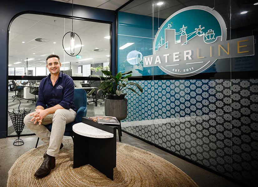 Tim Strong, Executive MBA graduate, sitting in the foyer of Waterline.