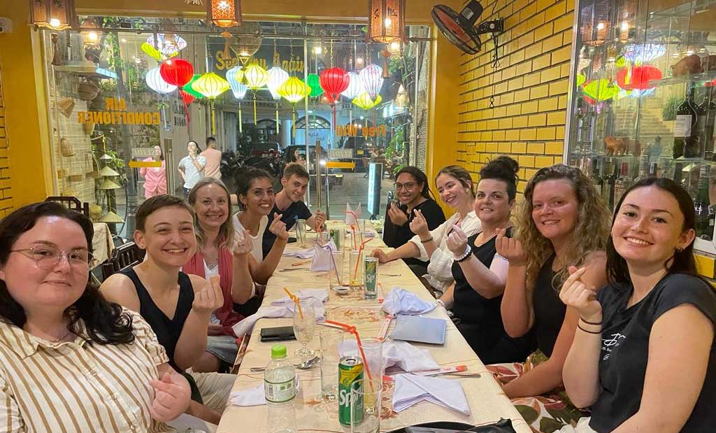 Students sitting in a busy restaurant.