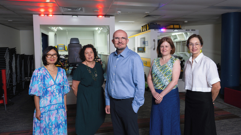 QUT and Metro North staff stand in an ambulance bay.