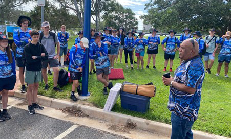 Uncle Cheng delivers a Welcome to Country with a group of high school students.