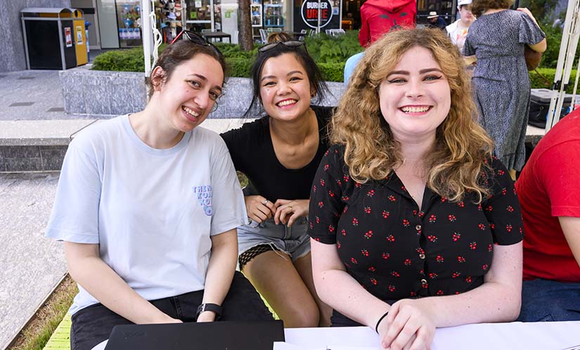 Three smiling women sign up new club members