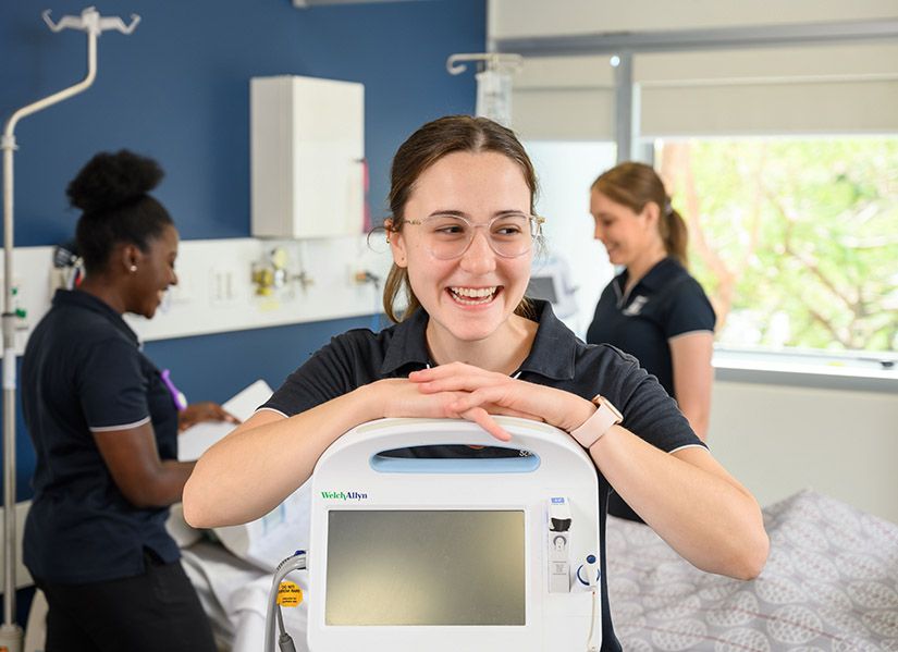 Smiling woman stands in clinical simulation centre