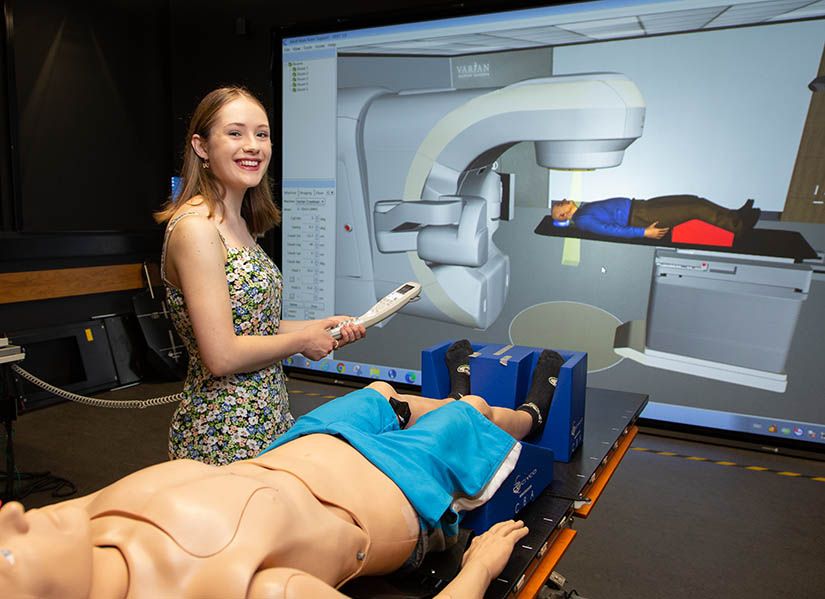 Female student standing in virtual radiotherapy laboratory