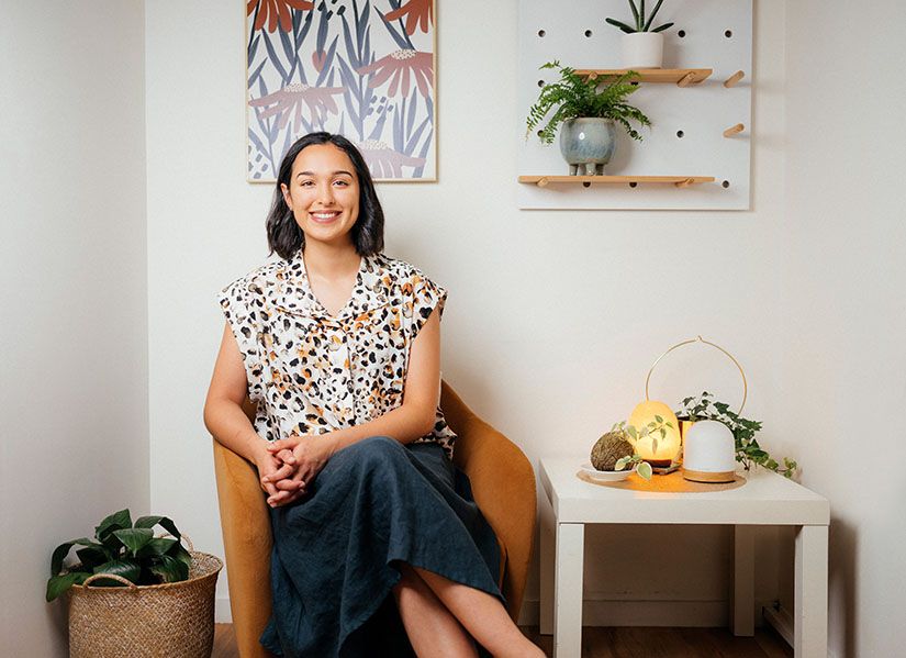 A smiling woman sits in a dietician's clinic.