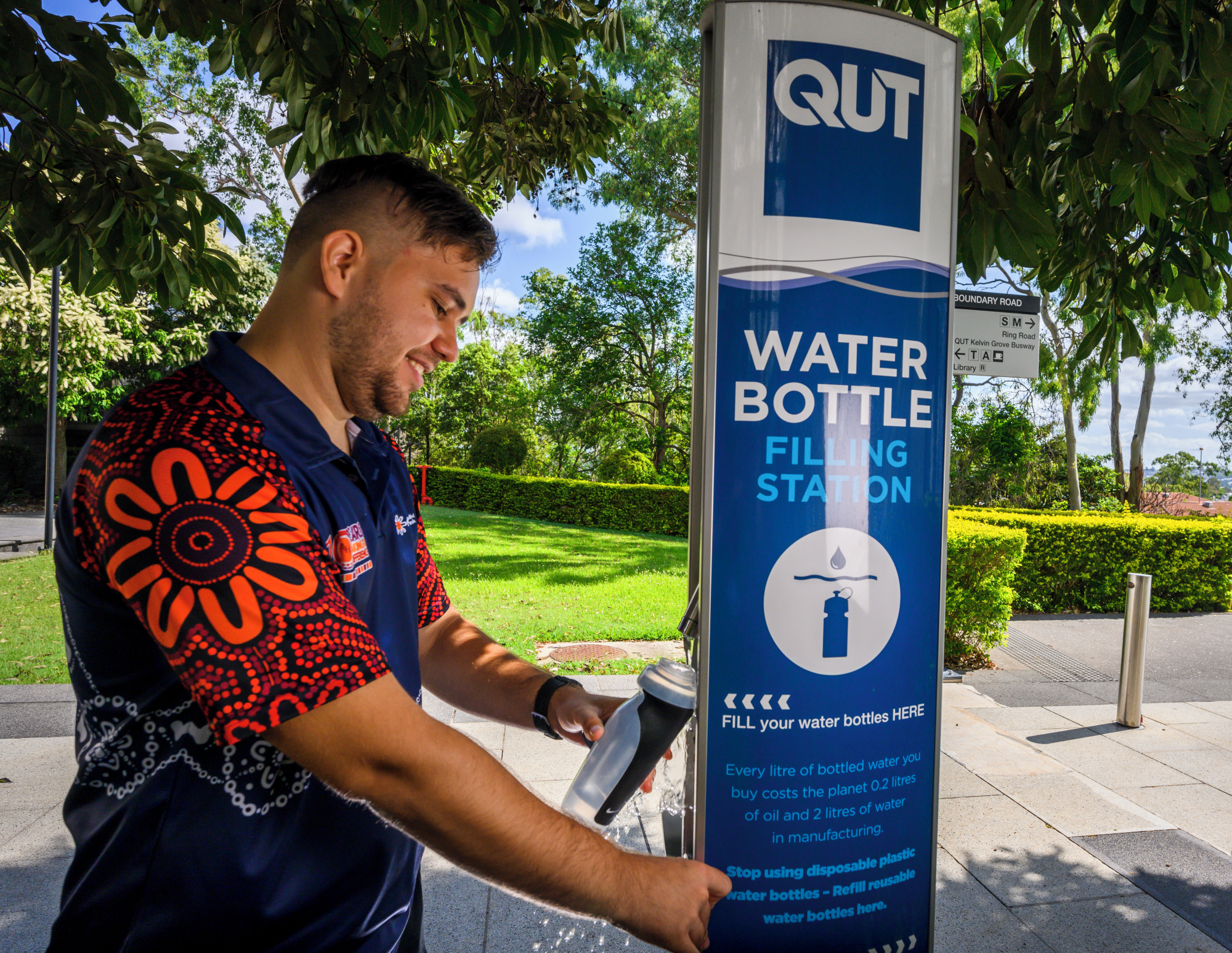 a man fills a water bottle from a water bottle filling station